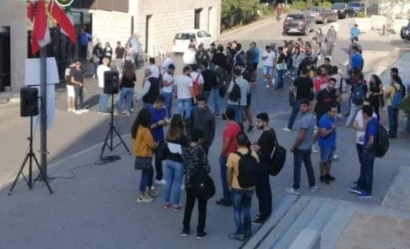 طلاب يتجمعون رافعين الأعلام داخل حرم جامعة البلمند في الكورة