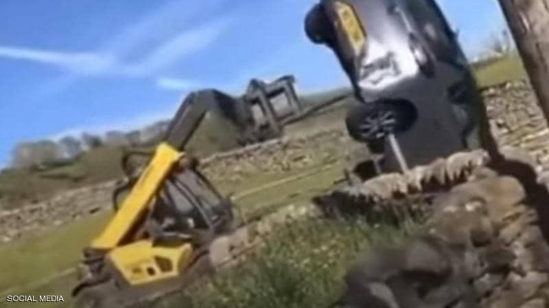 بالفيديو: مزارع غاضب يحطم سيارة باستخدام جرافة!